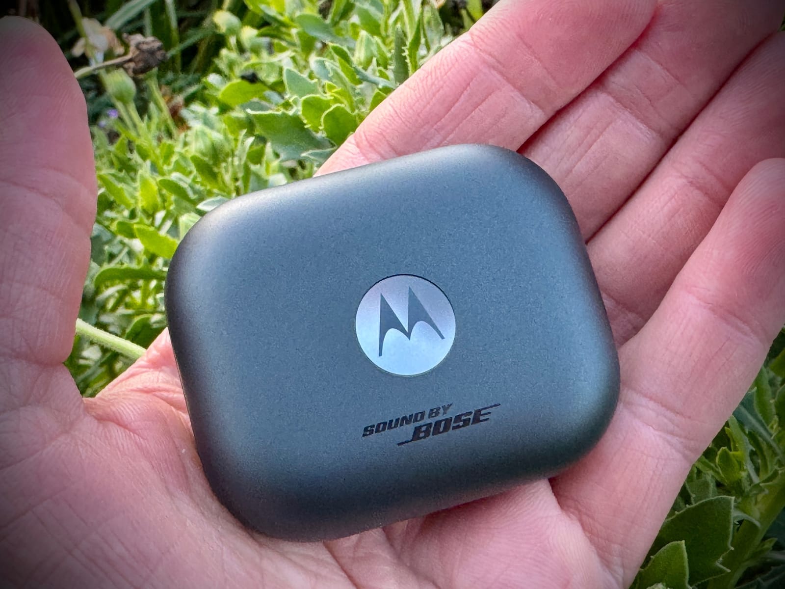 Motorola Moto Buds+ Sound by Bose em cima da palma da mão.