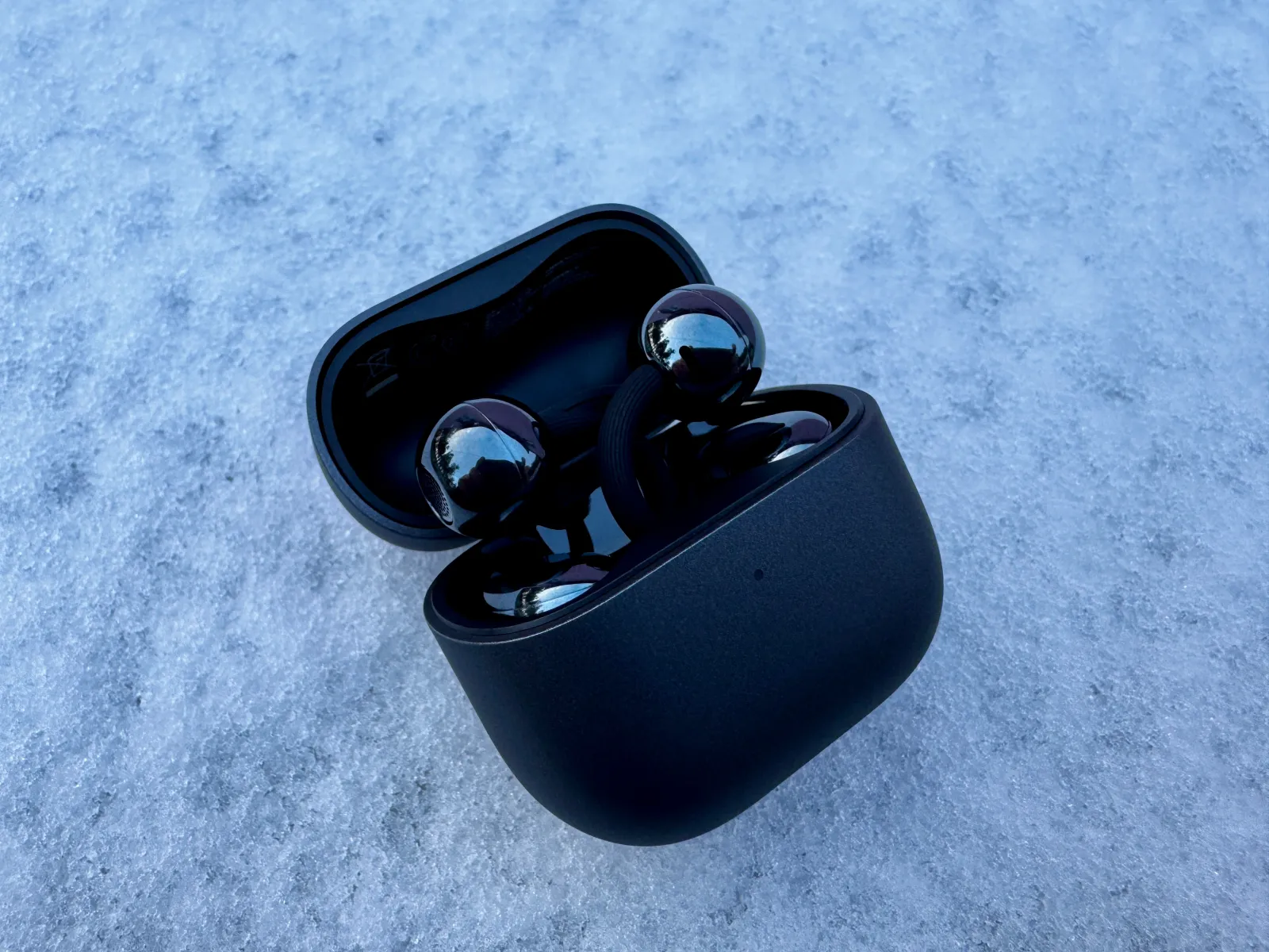 Os auriculares Huawei FreeClip 2 na cor preta em cima da neve.