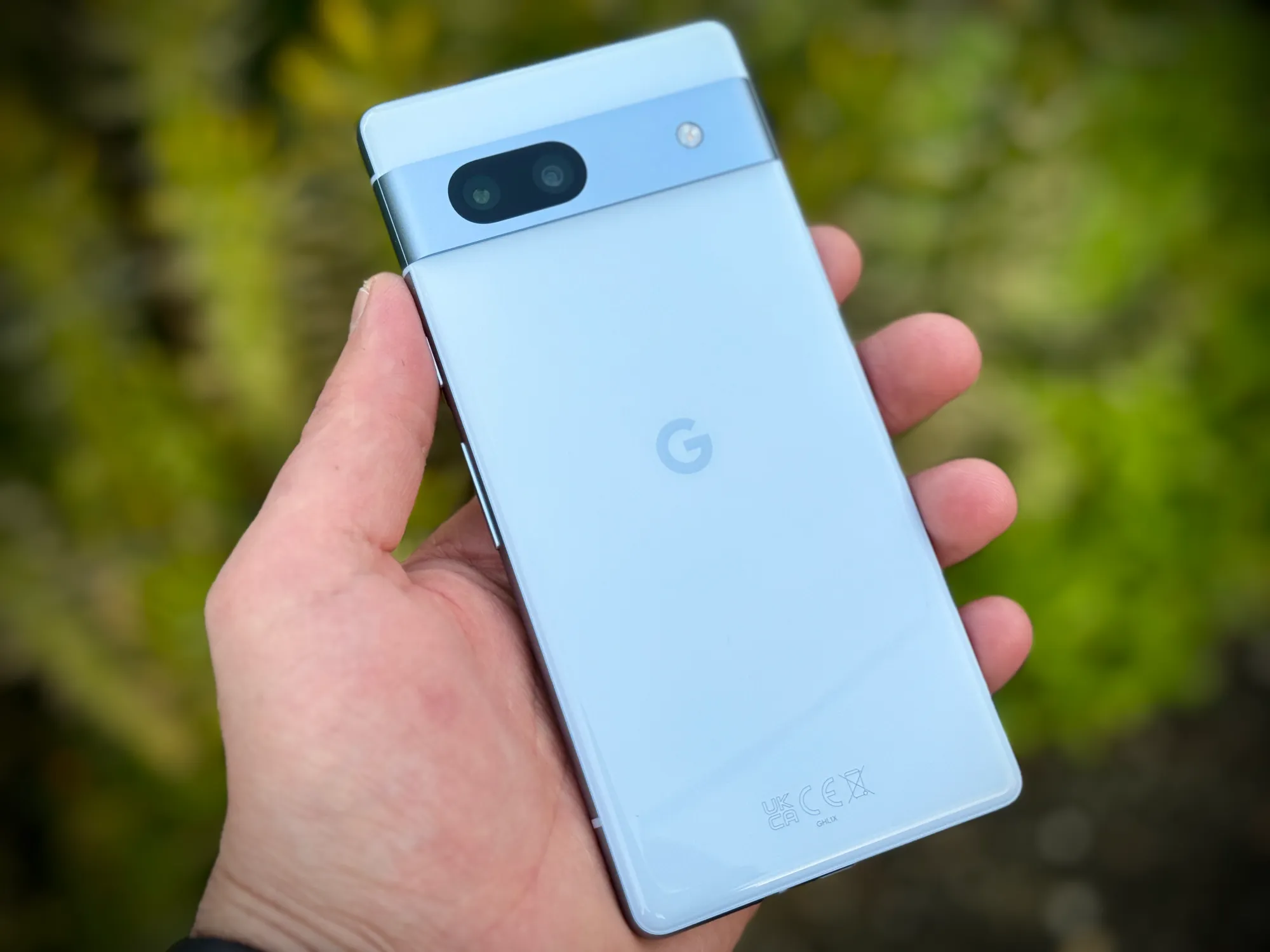 Uma mão a segurar um Google Pixel 7a na cor Oceano